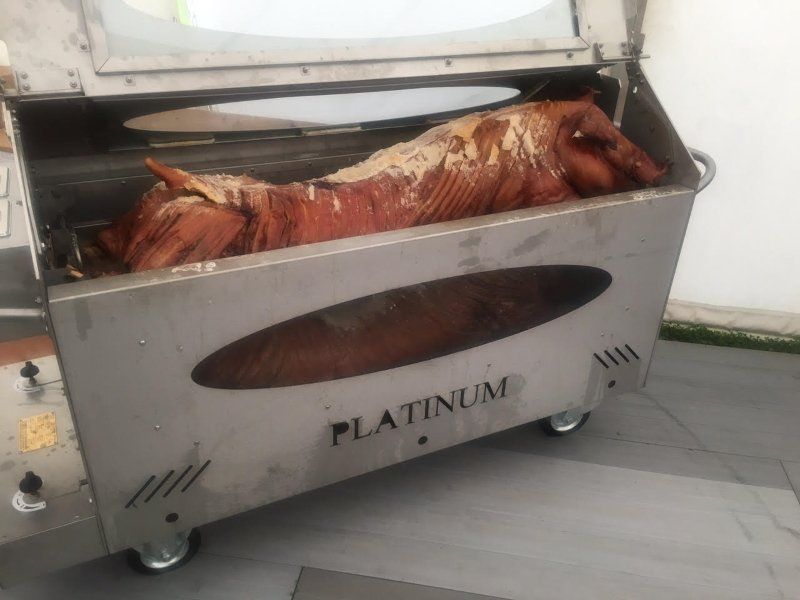 A pig is being cooked on a platinum grill