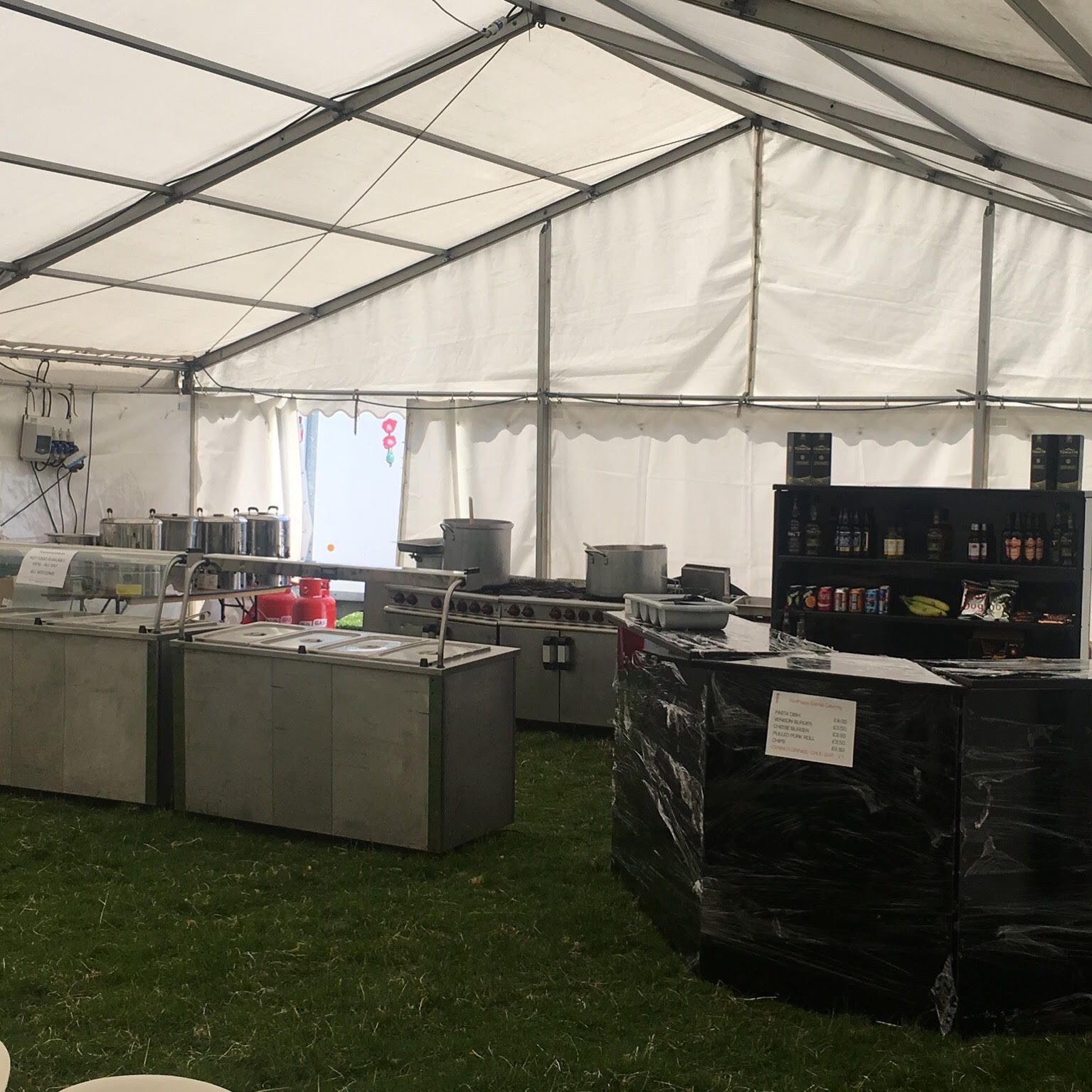 A large tent filled with lots of tables and appliances