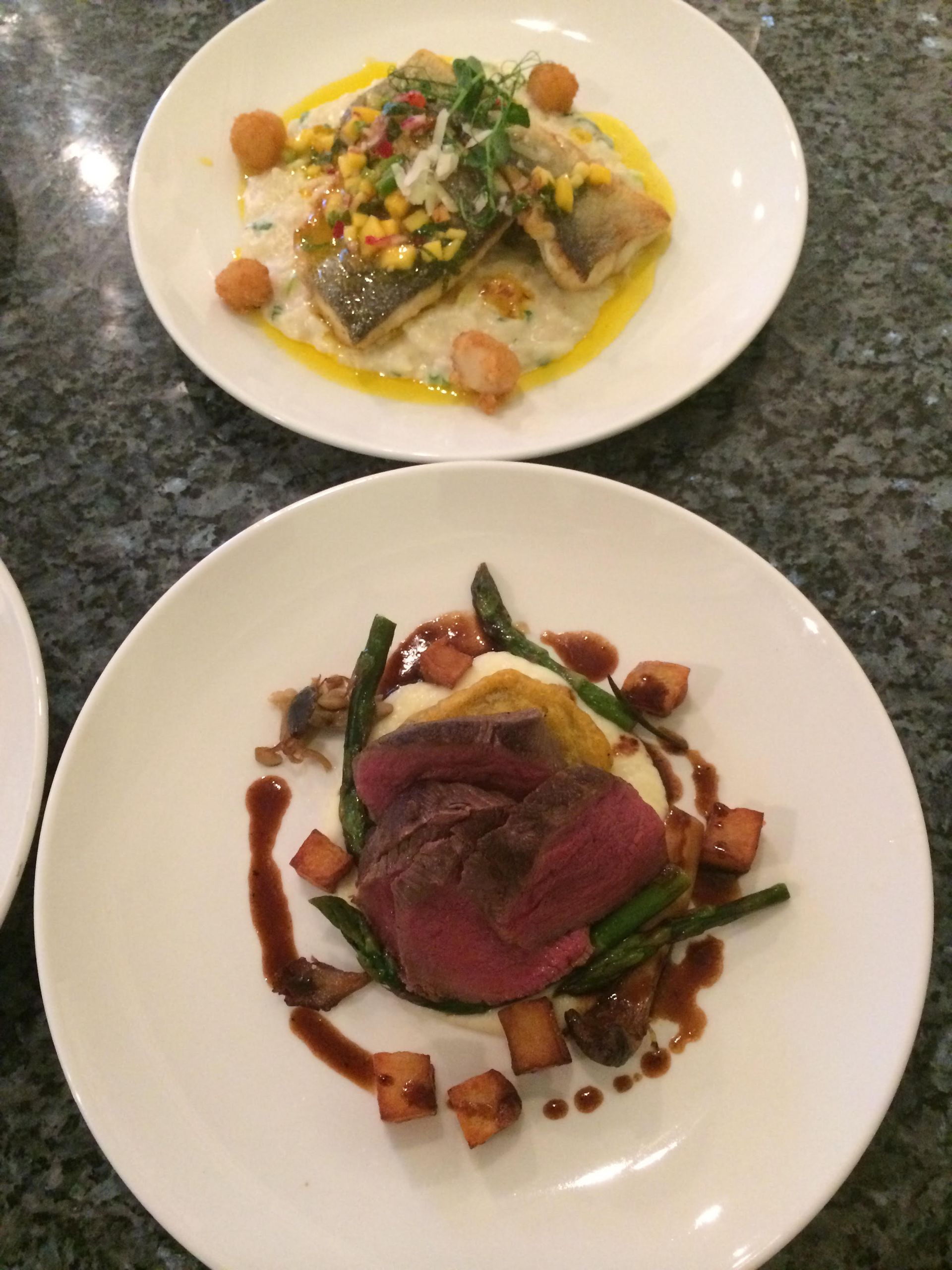 Two plates of food are sitting on a table.