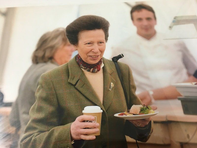 A woman holding a cup of coffee and a plate of food