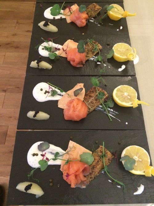 Four plates of food with lemon slices on them