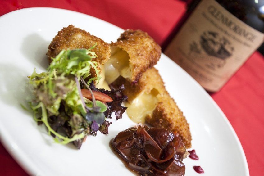 A plate of food with a bottle of glenmorangie in the background