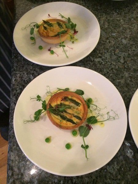 Two plates of food with asparagus and peas on them
