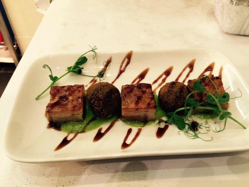 A white plate topped with meat and vegetables on a table