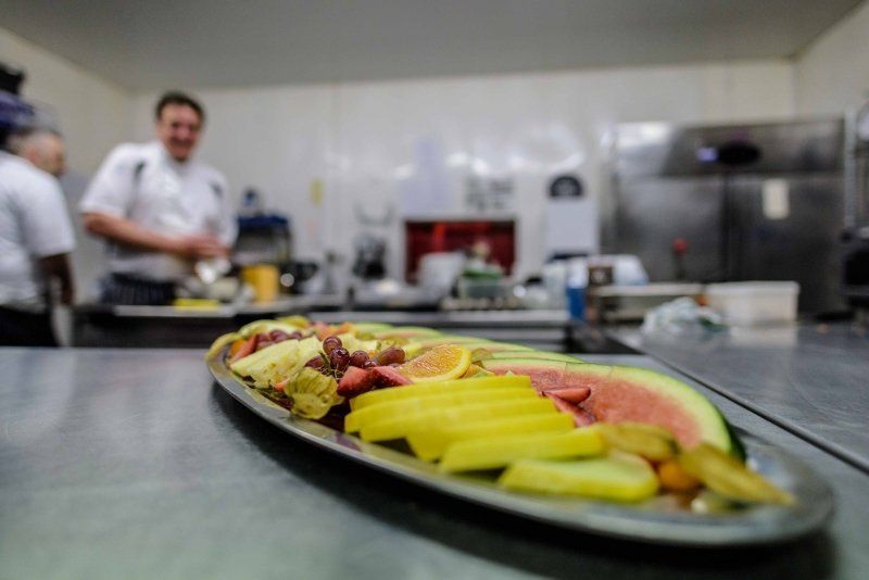 A plate of fruit sits on a counter in a kitchen
