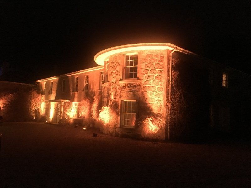 A large stone building is lit up at night.