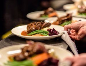 A person is holding a napkin over a plate of food.