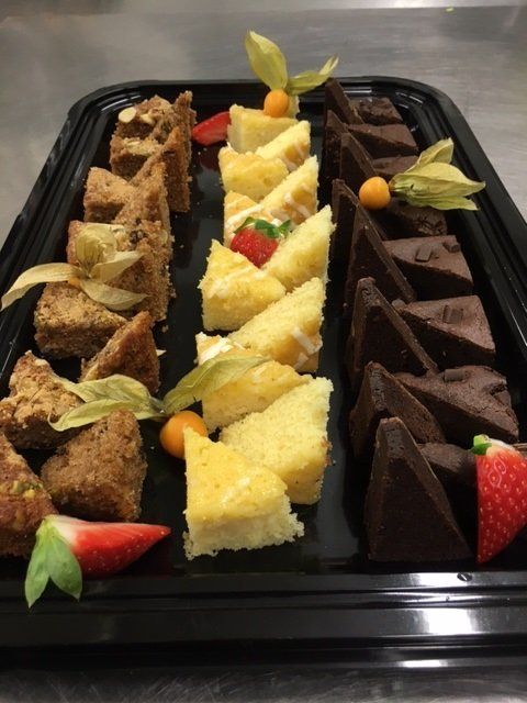 A black tray with a variety of desserts on it
