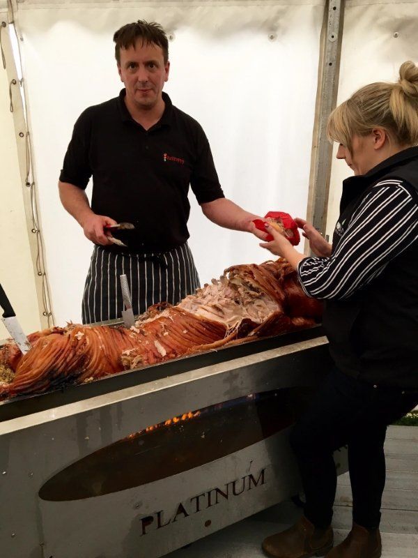 A man and a woman are standing in front of a platinum grill
