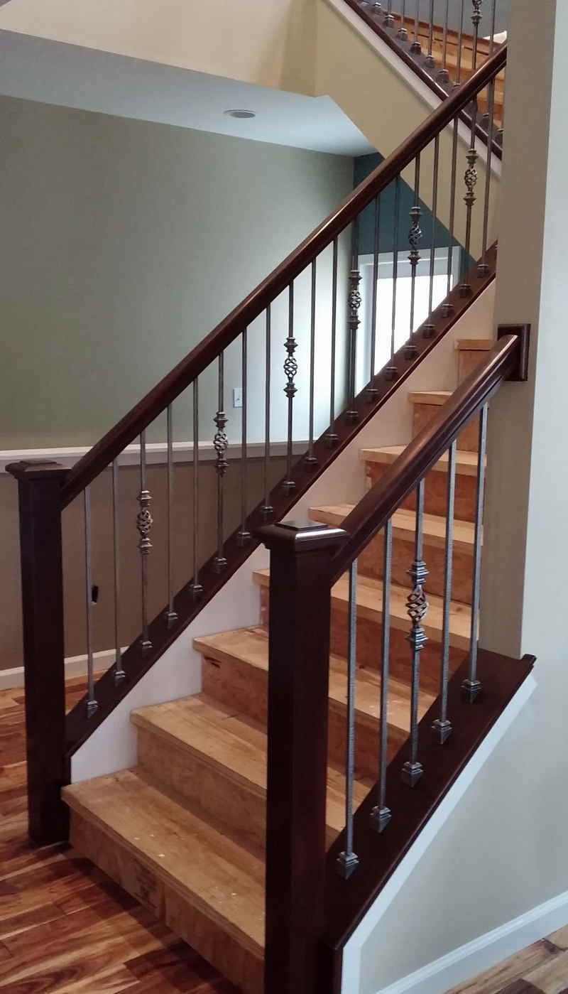 A wooden staircase with a metal railing in a house