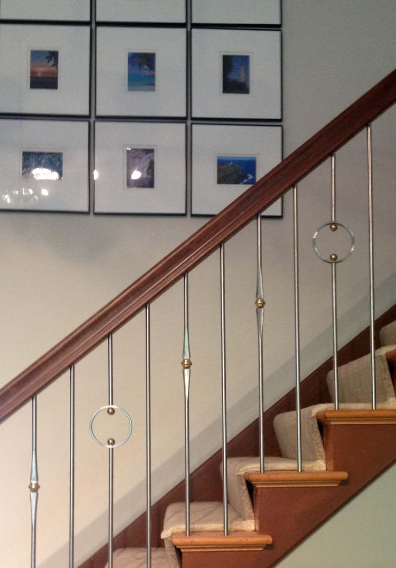 A staircase with pictures on the wall above it