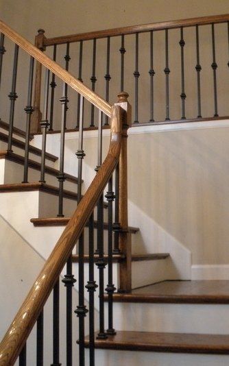 A staircase with a wooden railing and a metal railing