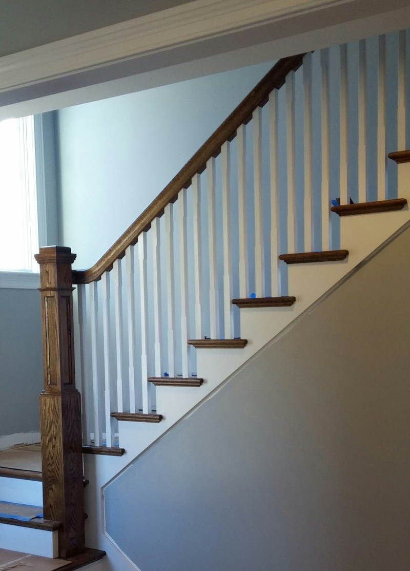 A staircase with a wooden railing and white steps