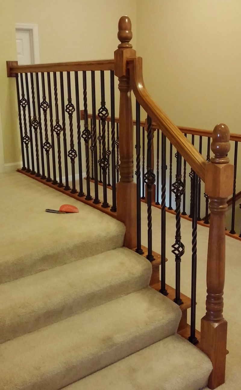 A staircase with a wooden railing and carpeted steps