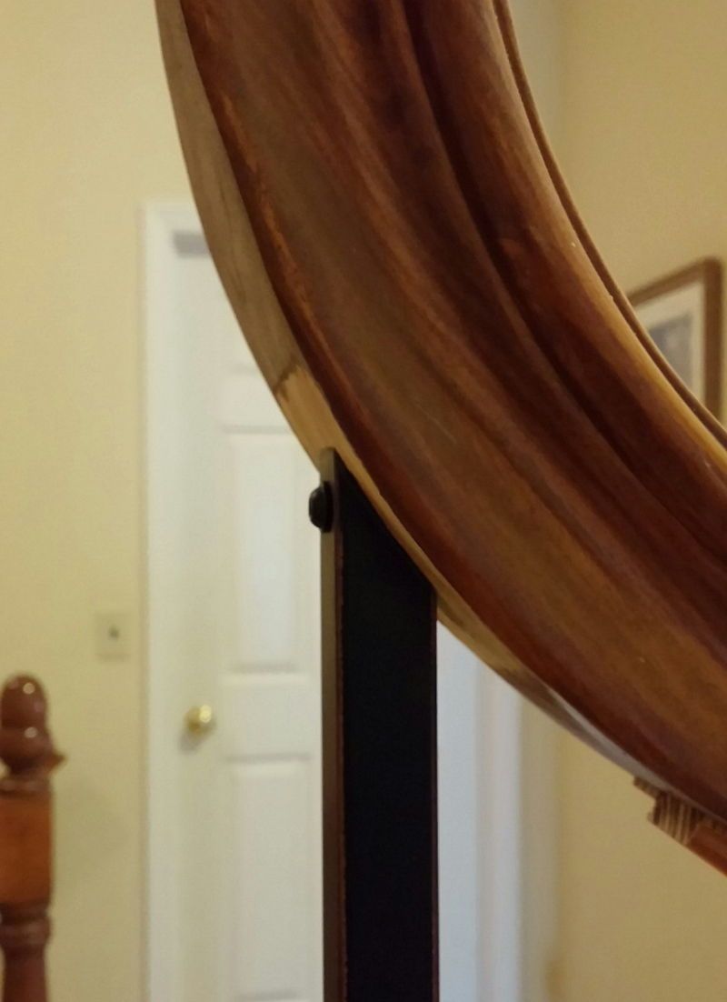 A close up of a wooden railing with a door in the background