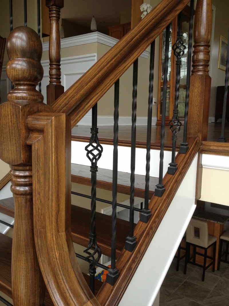 A wooden staircase with a wrought iron railing