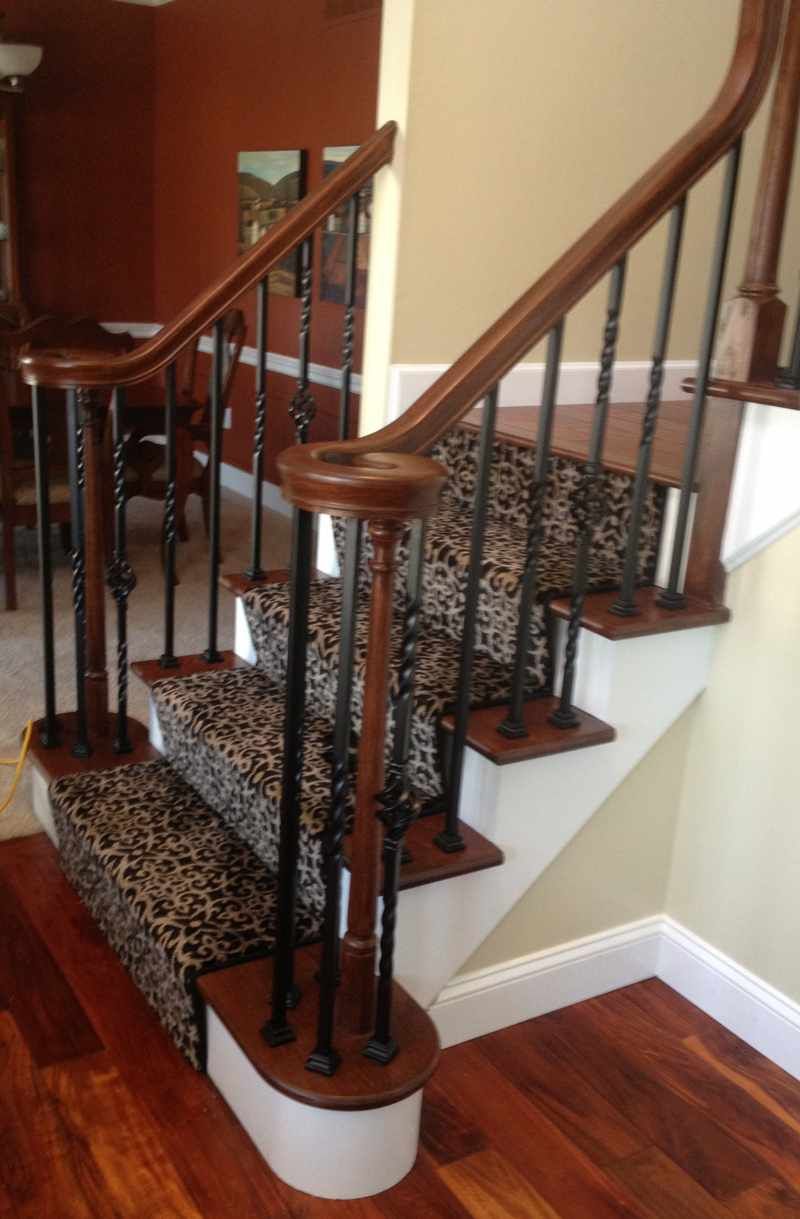 A staircase with a leopard print carpet and a wooden railing