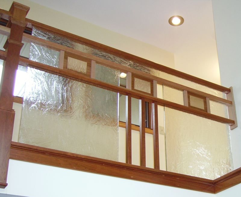 A staircase with a wooden railing and a glass railing