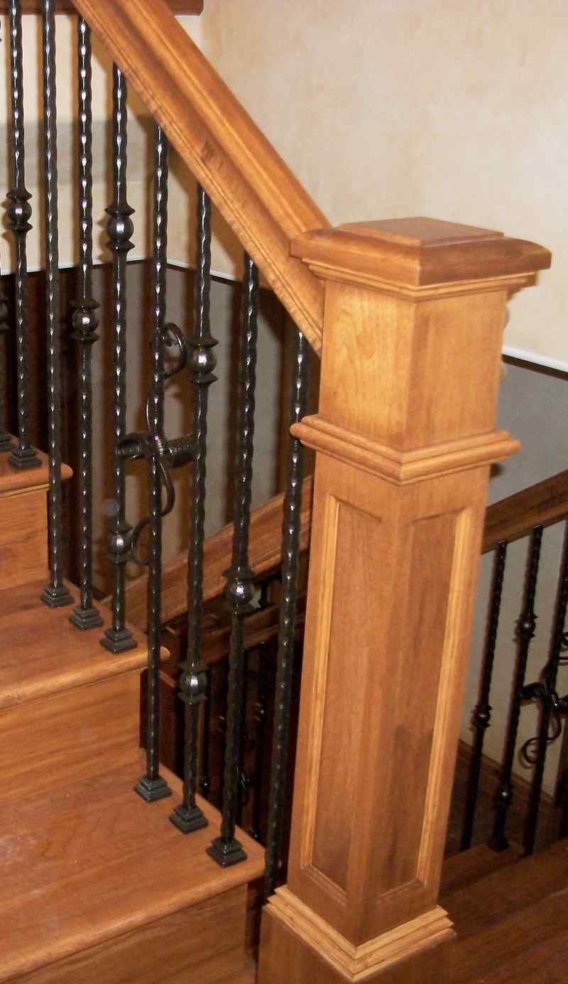 A wooden staircase with a wrought iron railing