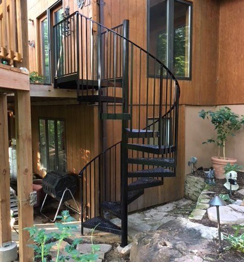 A wooden house with a spiral staircase leading up to the second floor