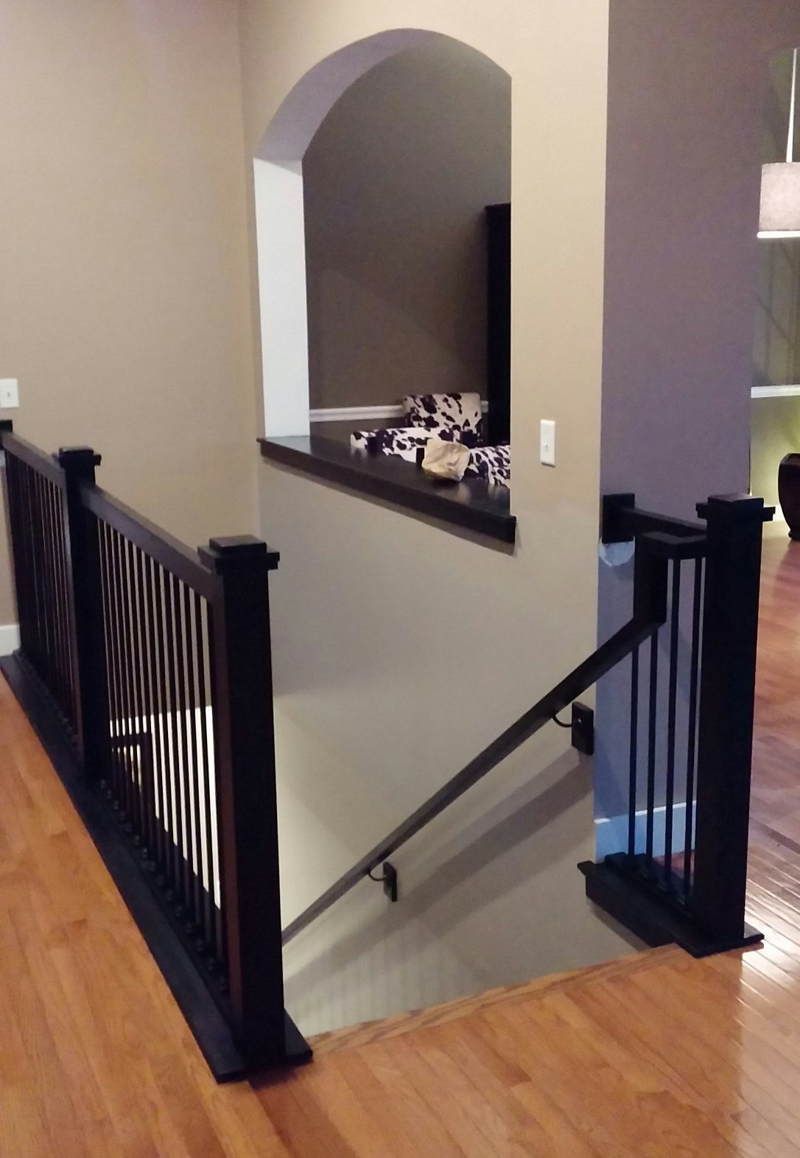A staircase in a house with a black railing