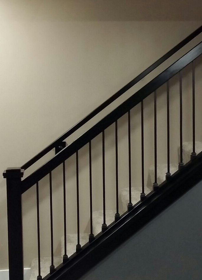 A close up of a staircase with a black railing