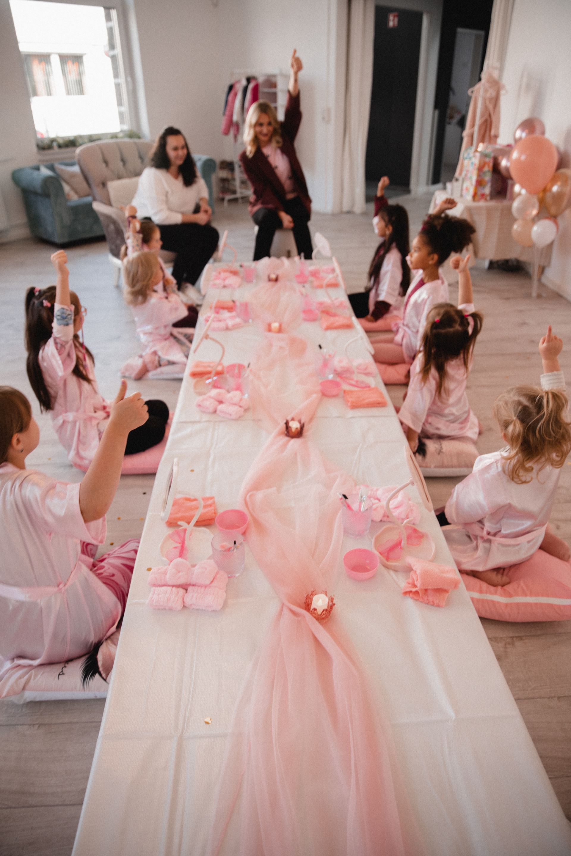 Eine Gruppe Kinder sitzt um einen langen Tisch herum.