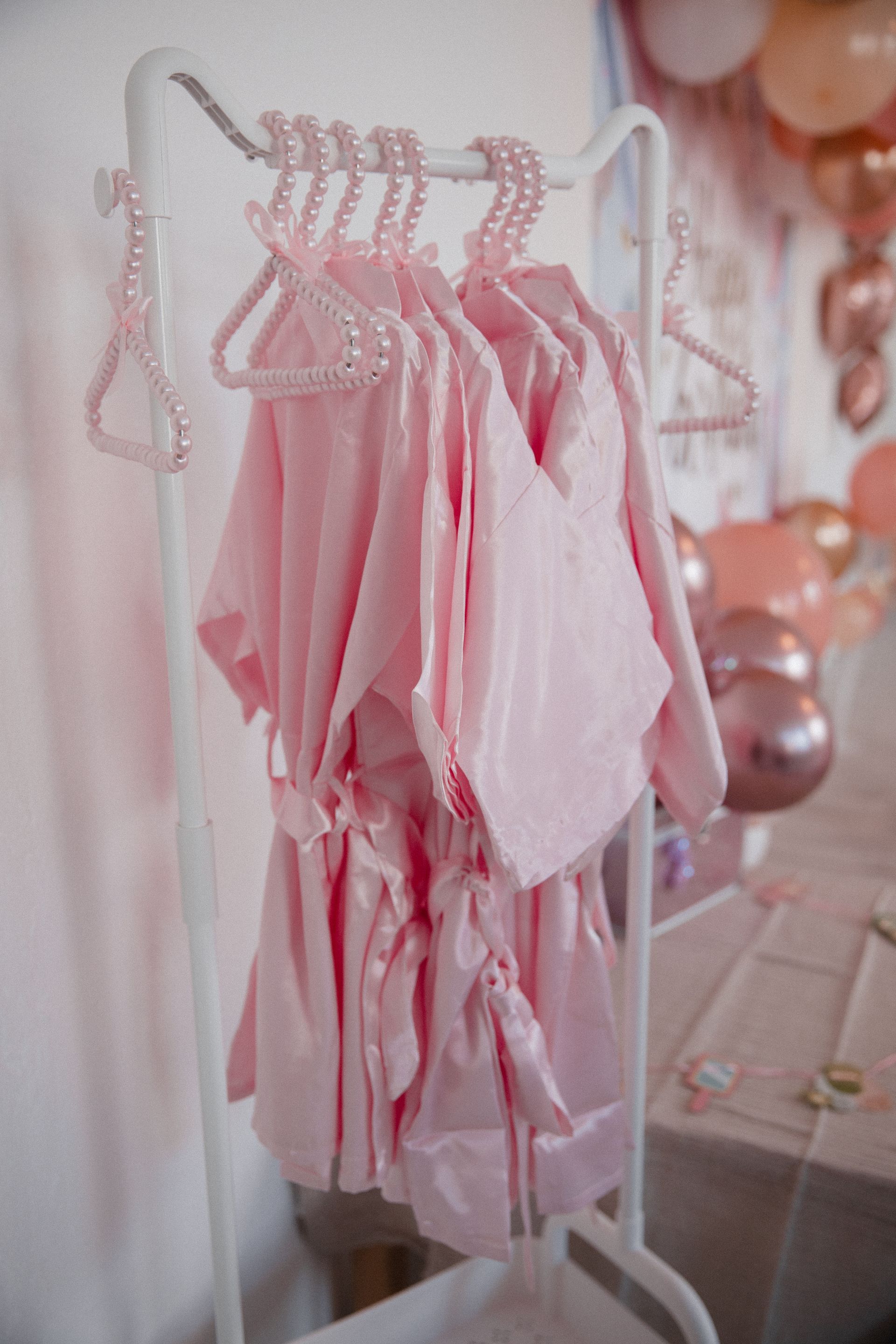 Ein Bündel rosafarbener Kleidungsstücke hängt an einer Kleiderstange.