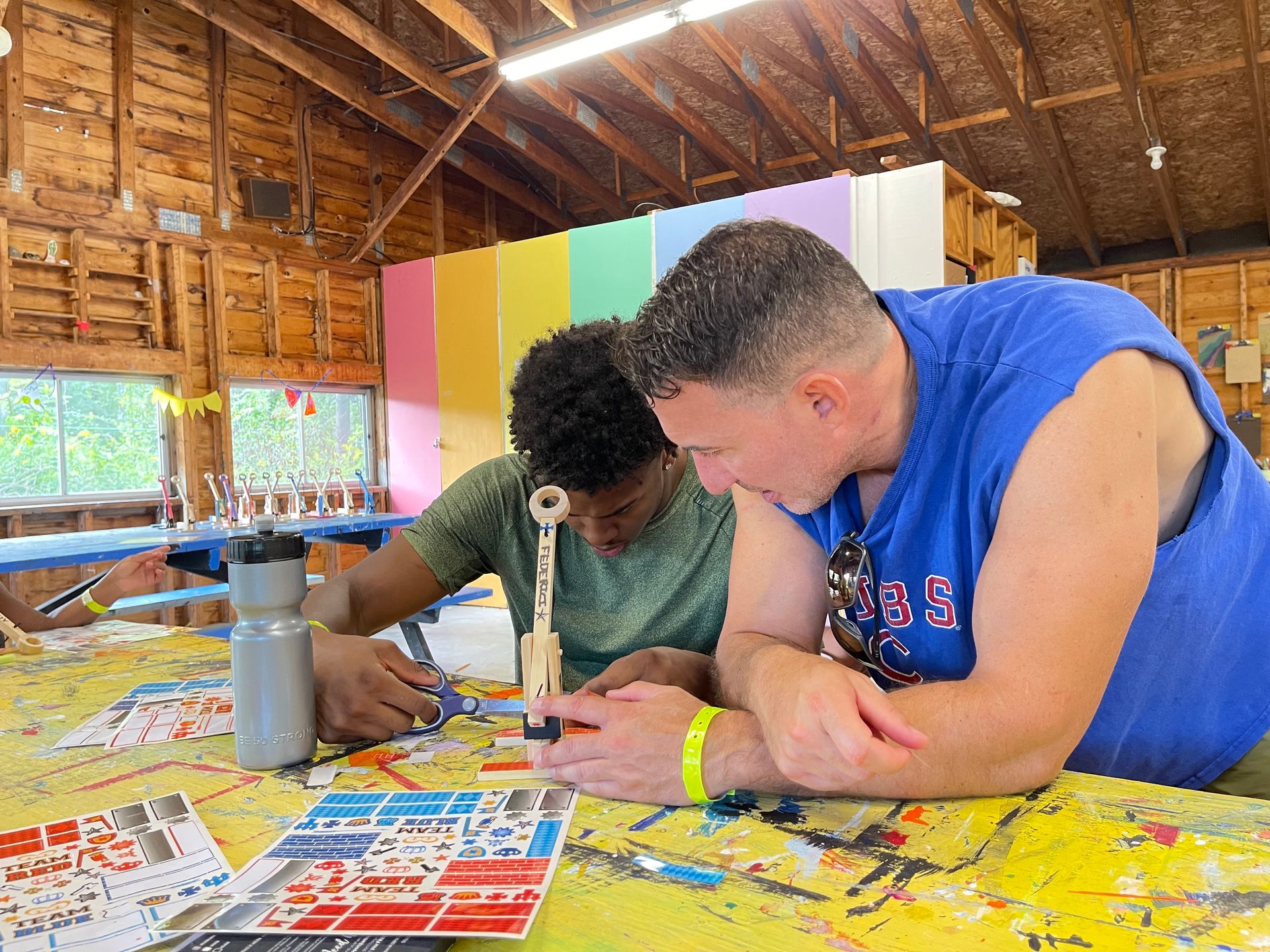 activities coordinator helping a teen CIT build a catapult