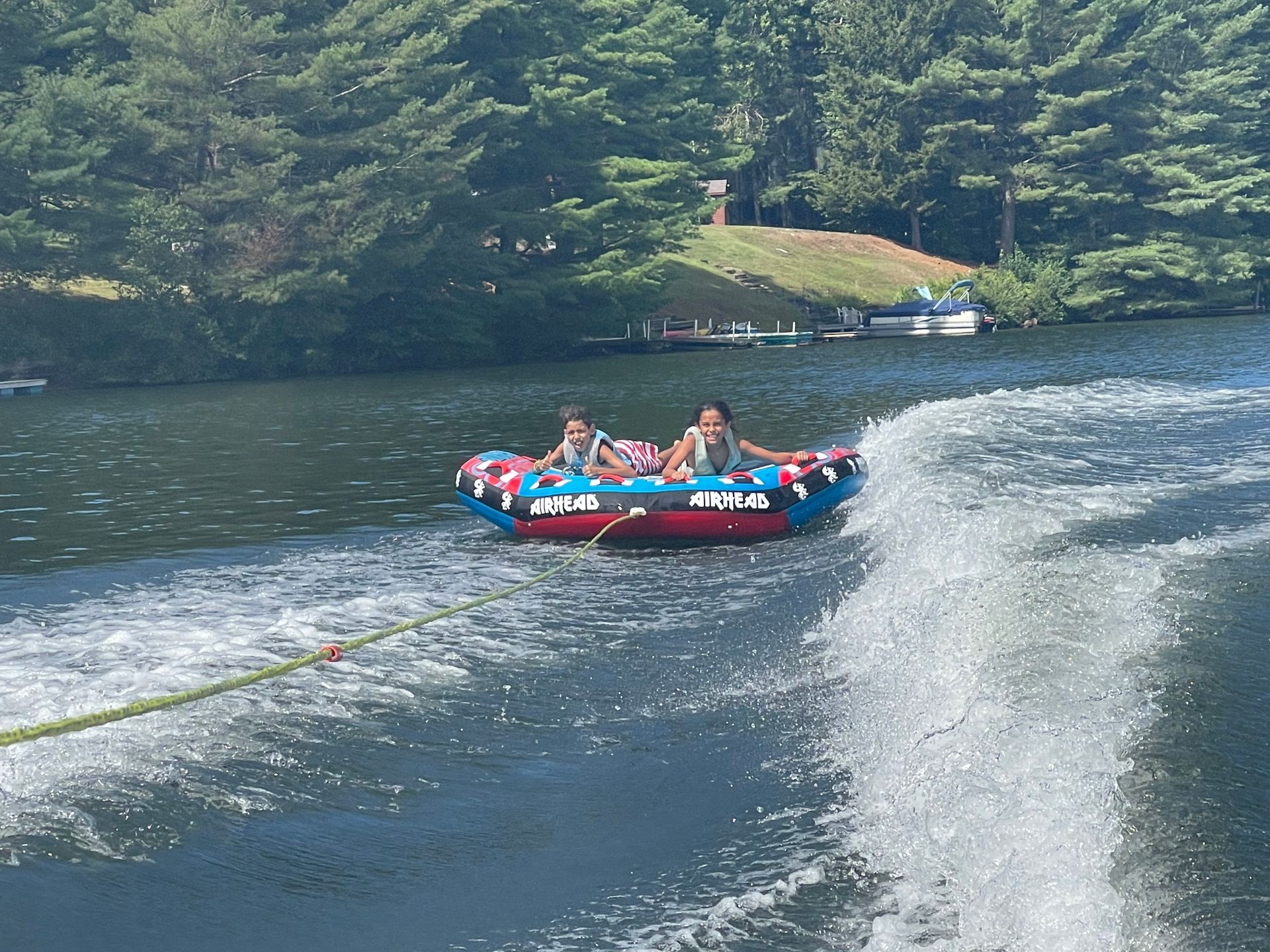 two kids water tubing on the lake