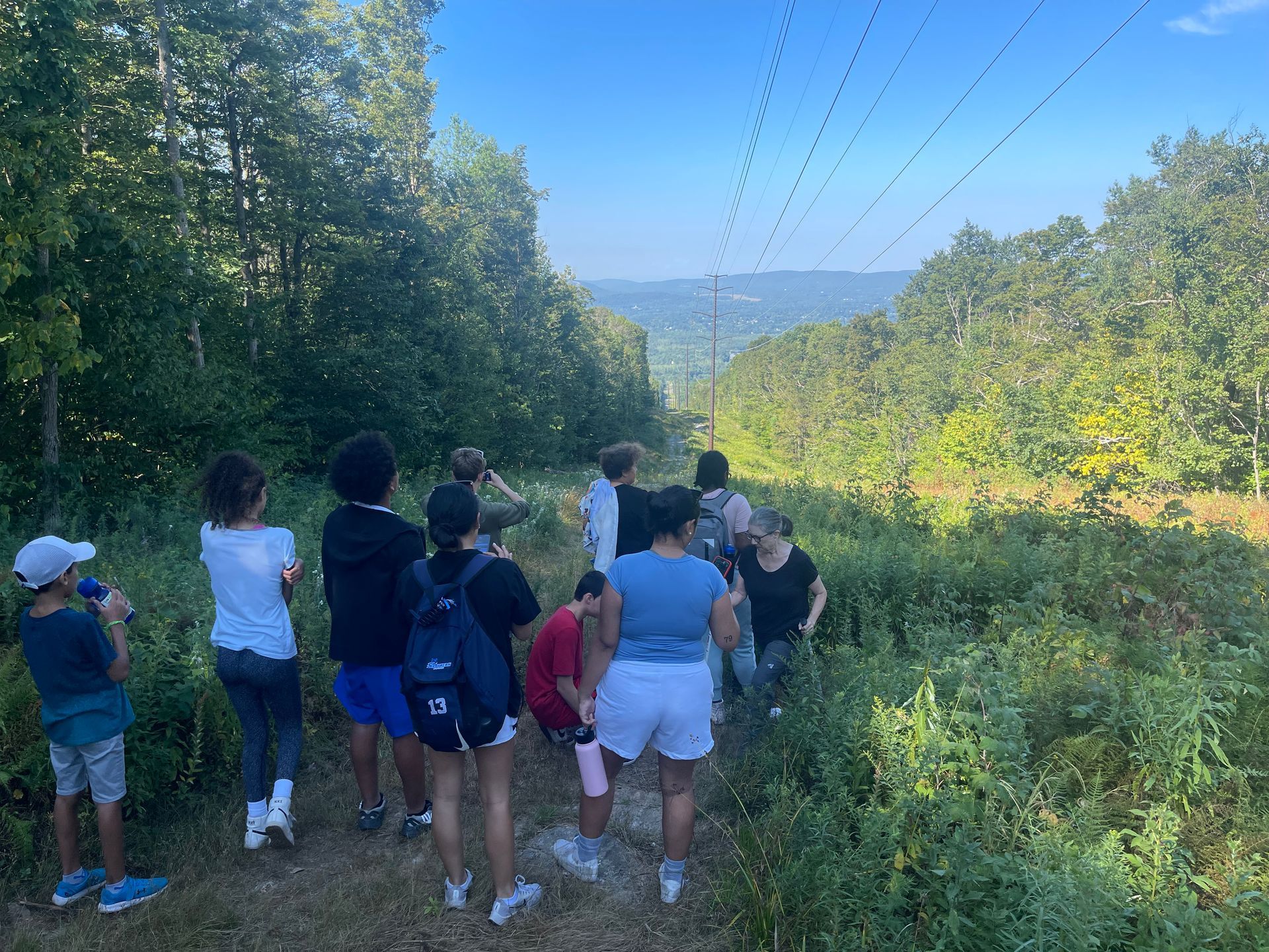 a group of campers and counselors walking in the woods
