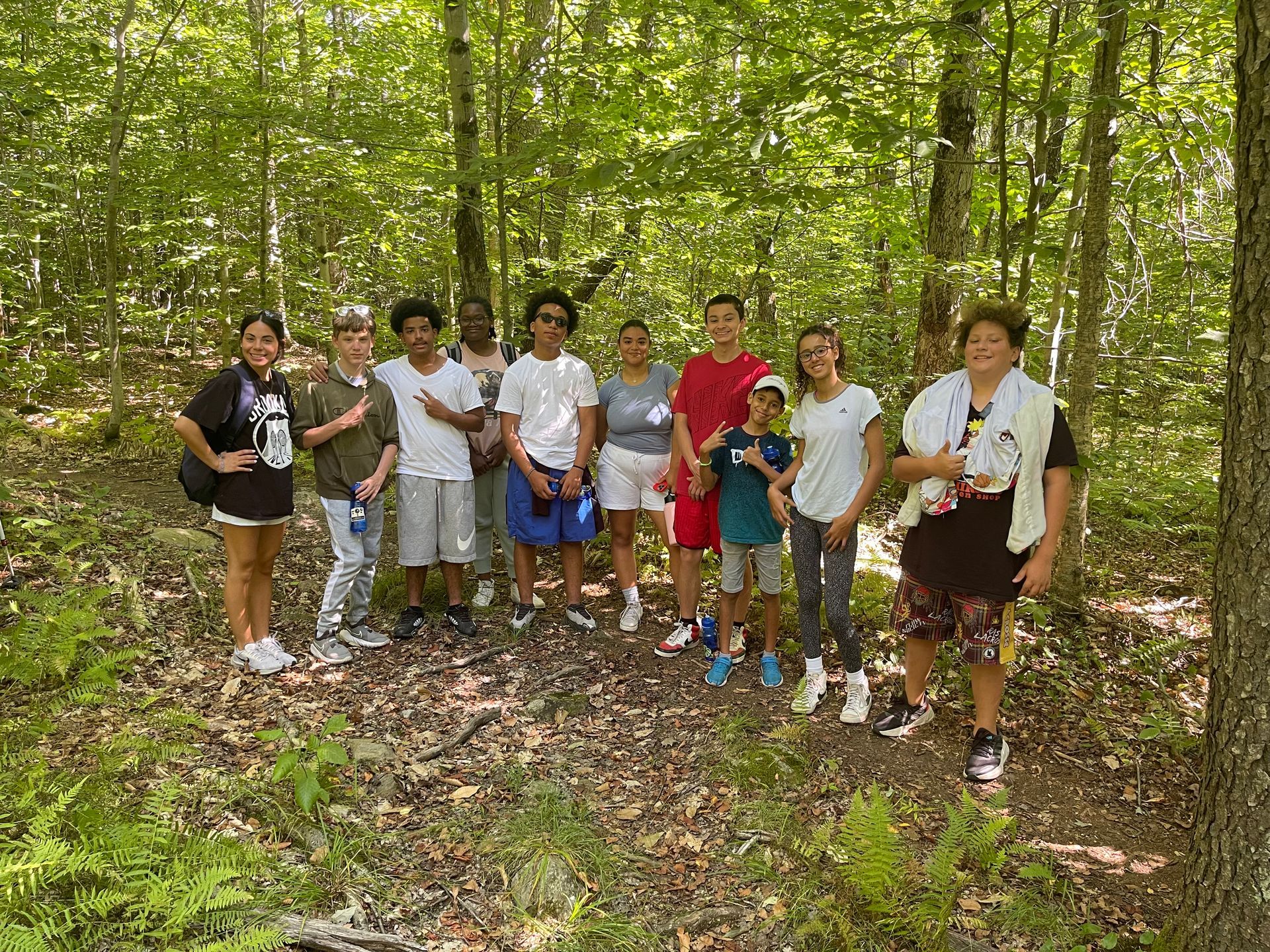 small group of campers and counselors on a hiking trail