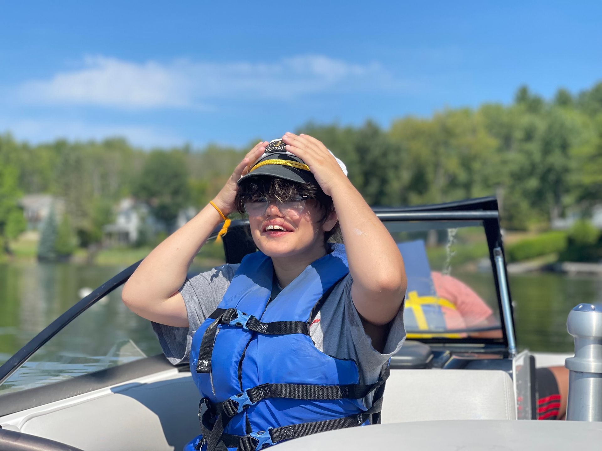 young girl on a boat wearing a captain's hat