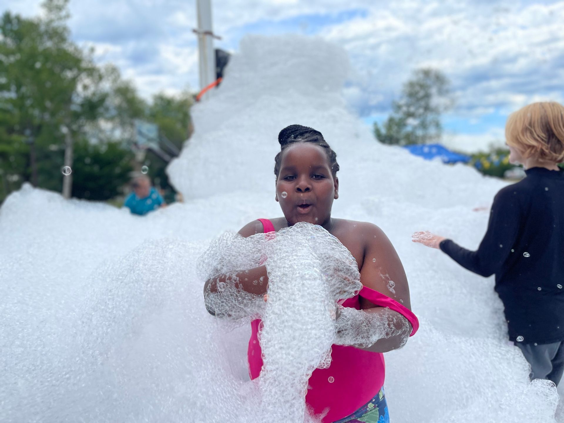 young girl blowing foam bubbles