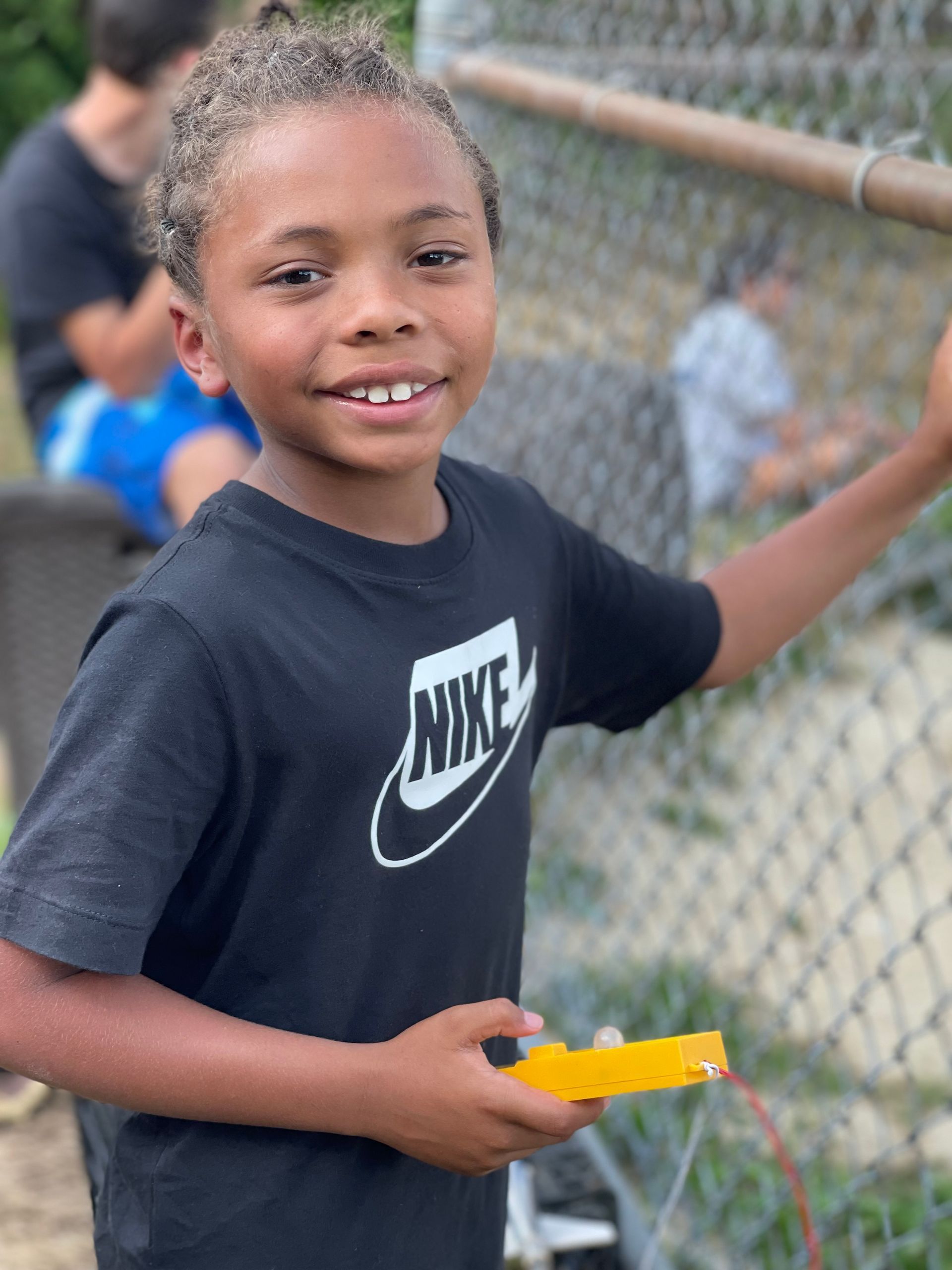camper smiling and holding rocket launchpad