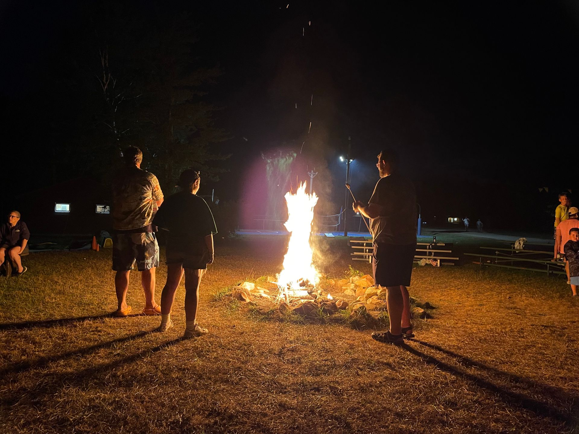 a group of counselors standing around a campfire