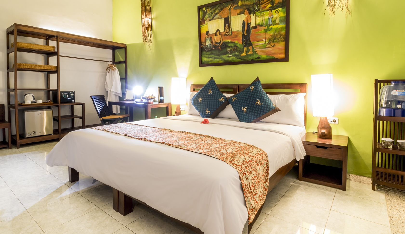 A hotel room with a large bed and a painting on the wall.