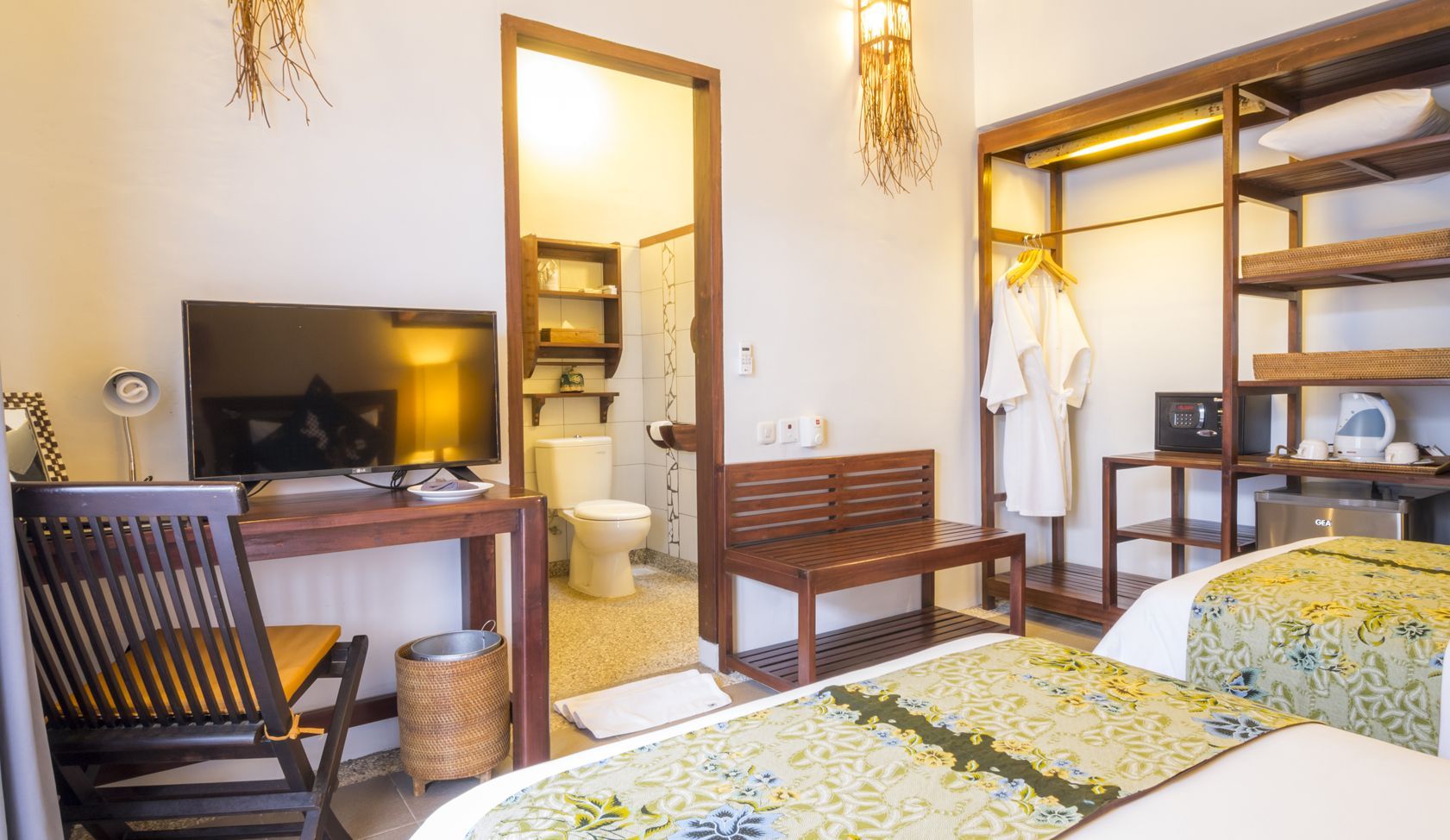 A hotel room with two beds , a desk , a television and a chair.