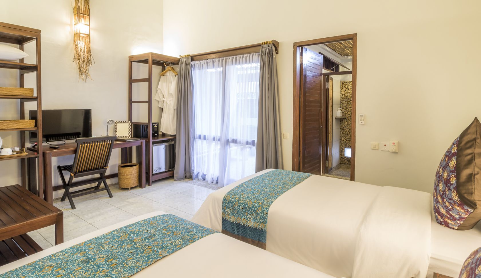 A hotel room with two beds , a desk and a television.