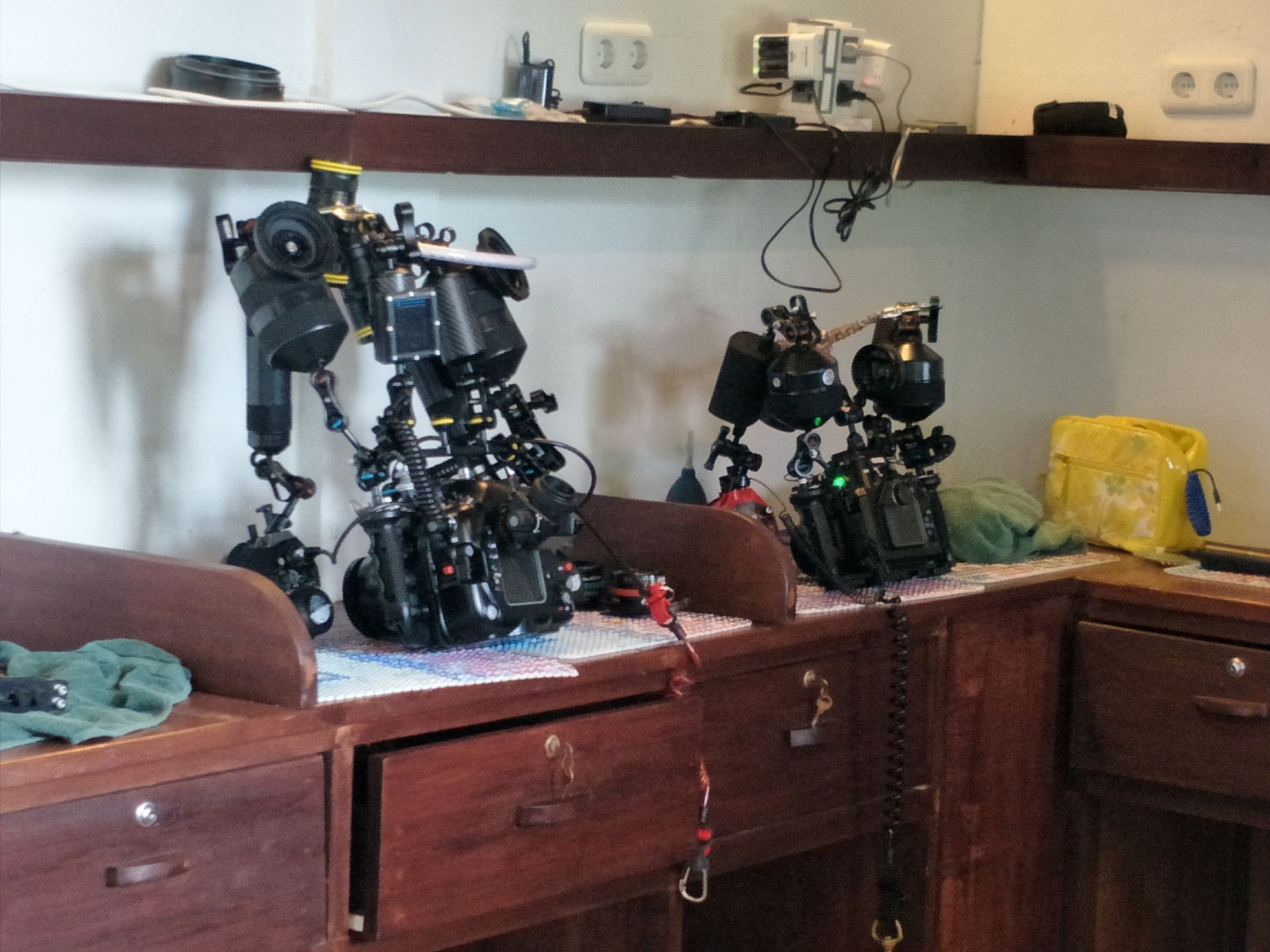 A bunch of cameras are sitting on a wooden table
