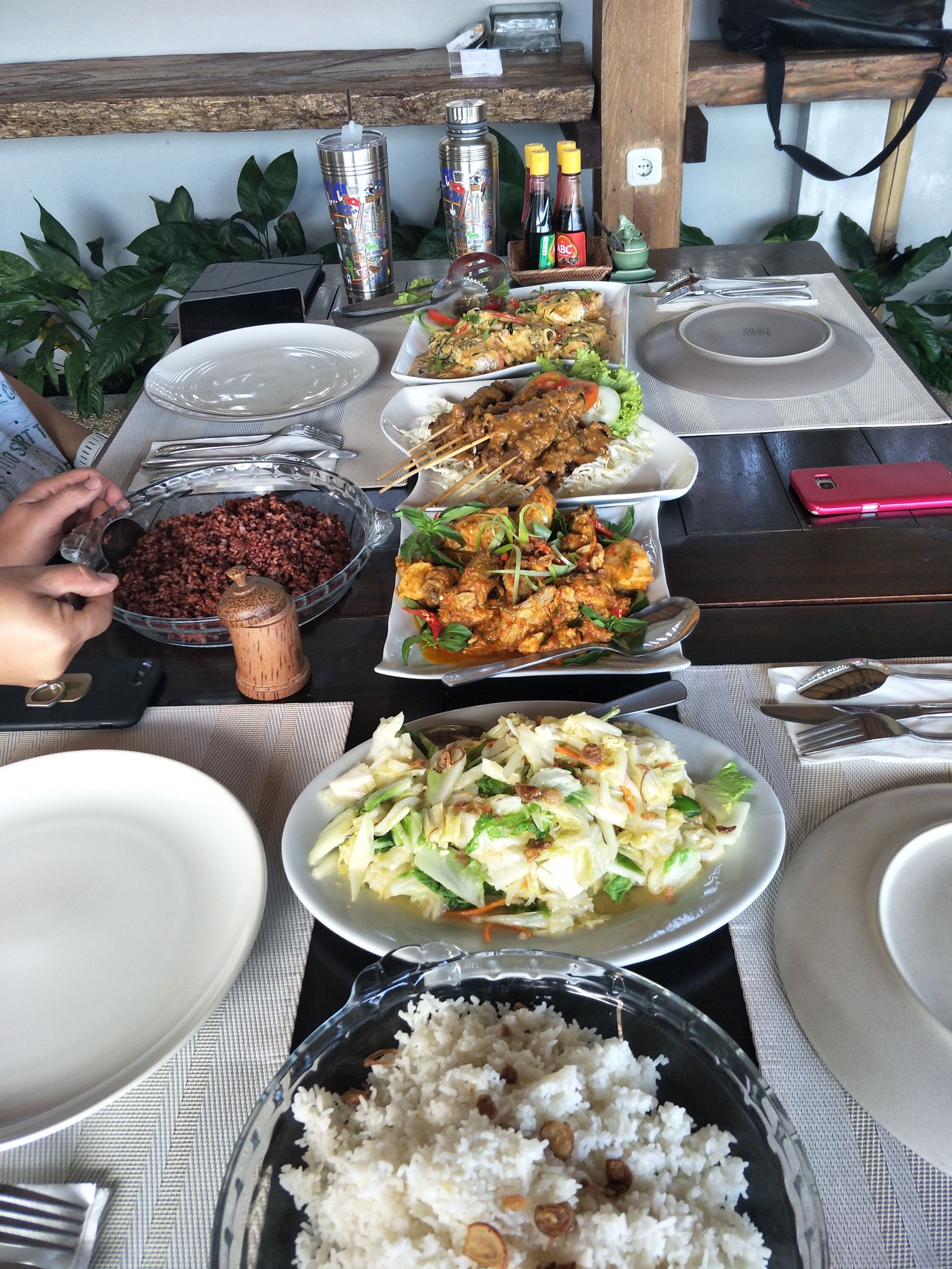 A table topped with plates of food including rice and fish.