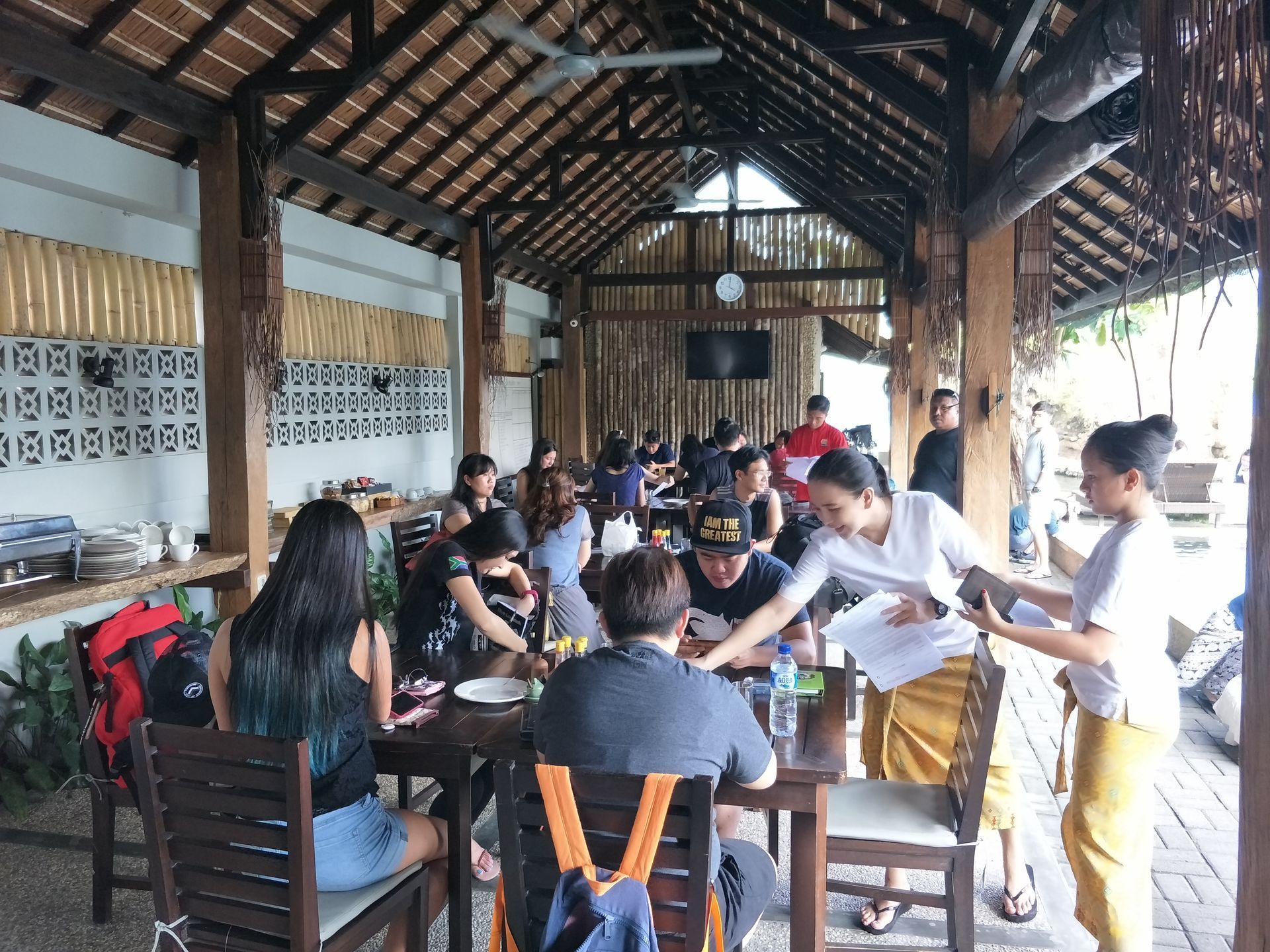 A group of people are sitting at tables in a restaurant.