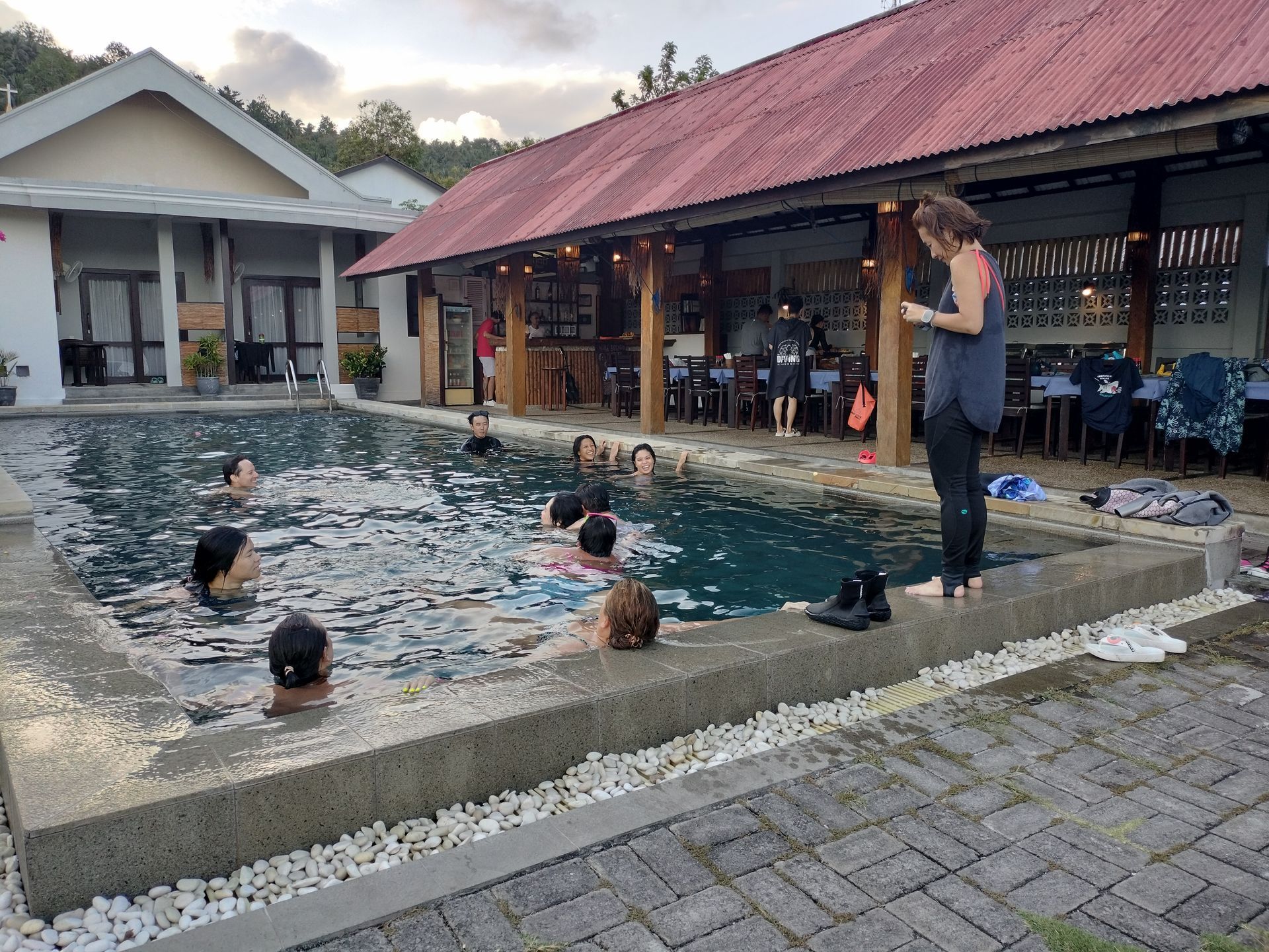A group of people are swimming in a large swimming pool.