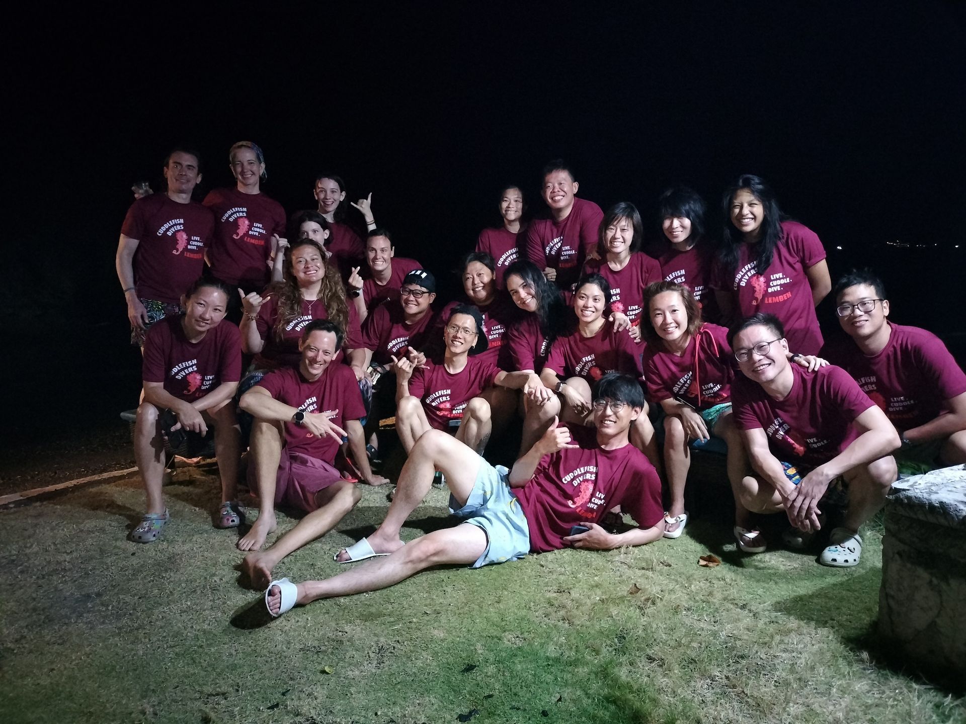 A group of people are posing for a picture at night.
