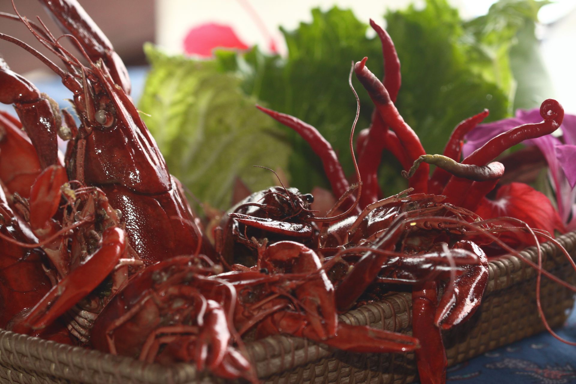 A basket filled with red peppers and lettuce on a table