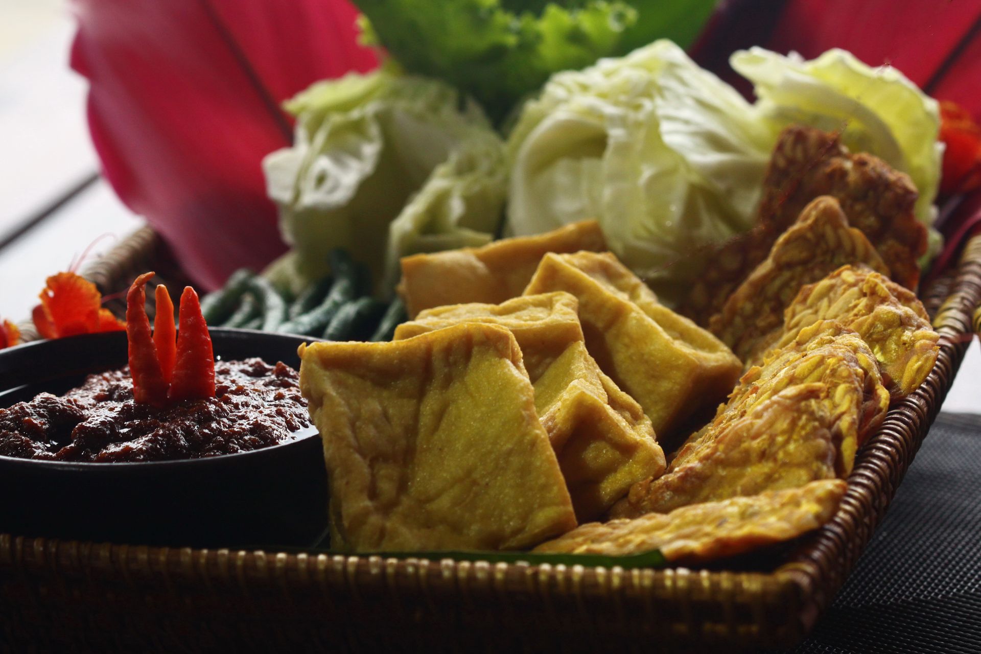 A basket filled with fried food and vegetables on a table.