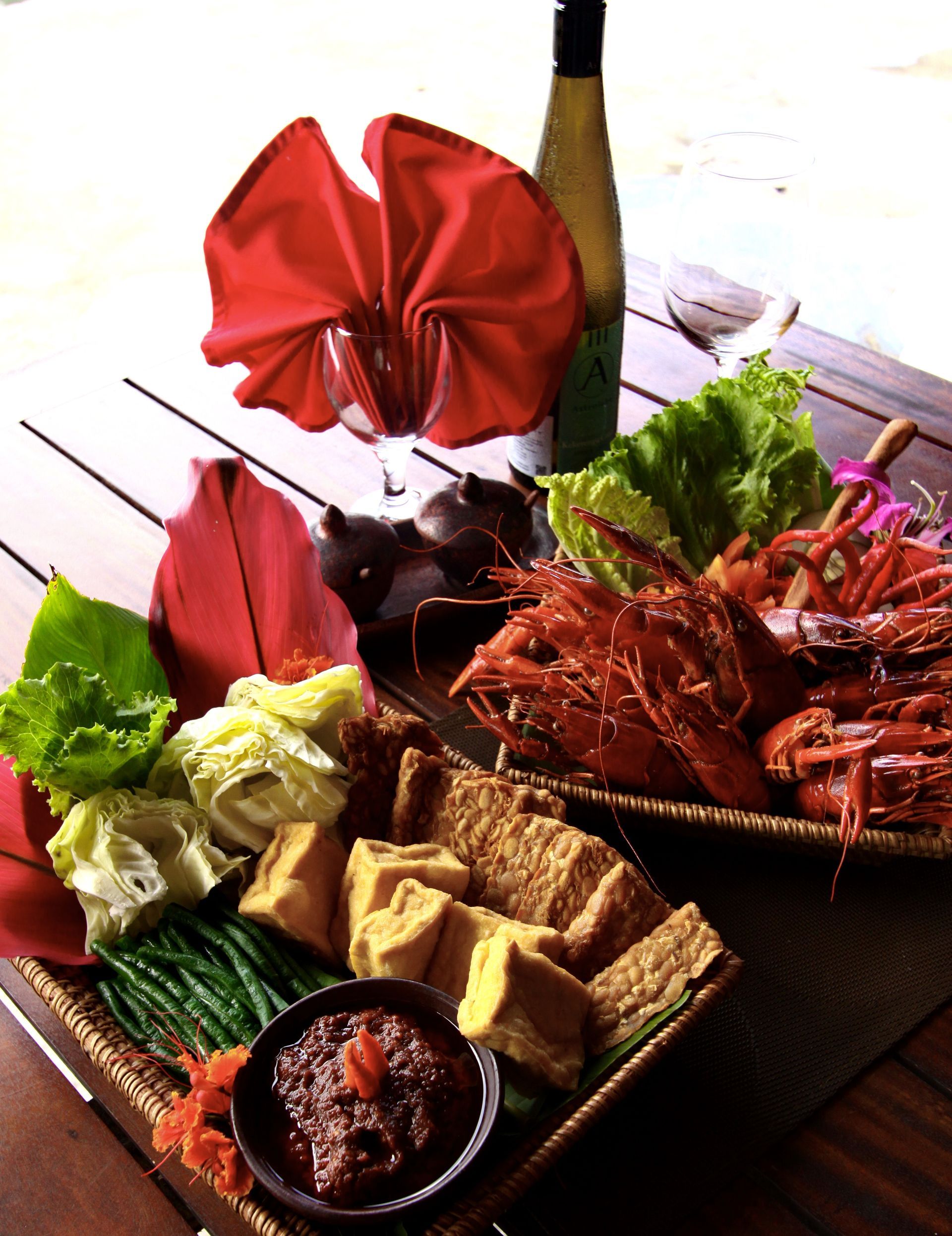 A table topped with plates of food and a bottle of wine