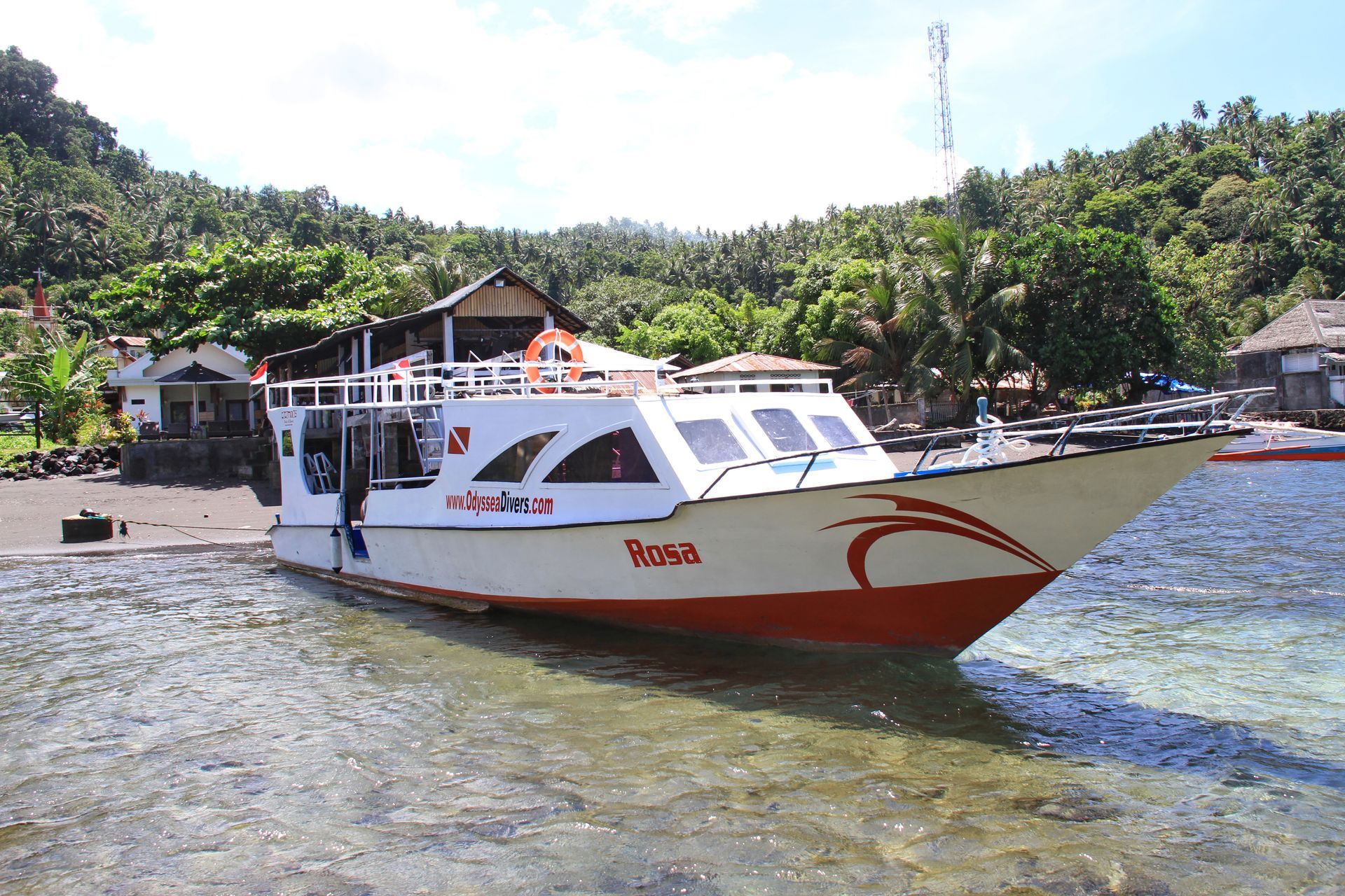 A red and white boat is docked in a body of water