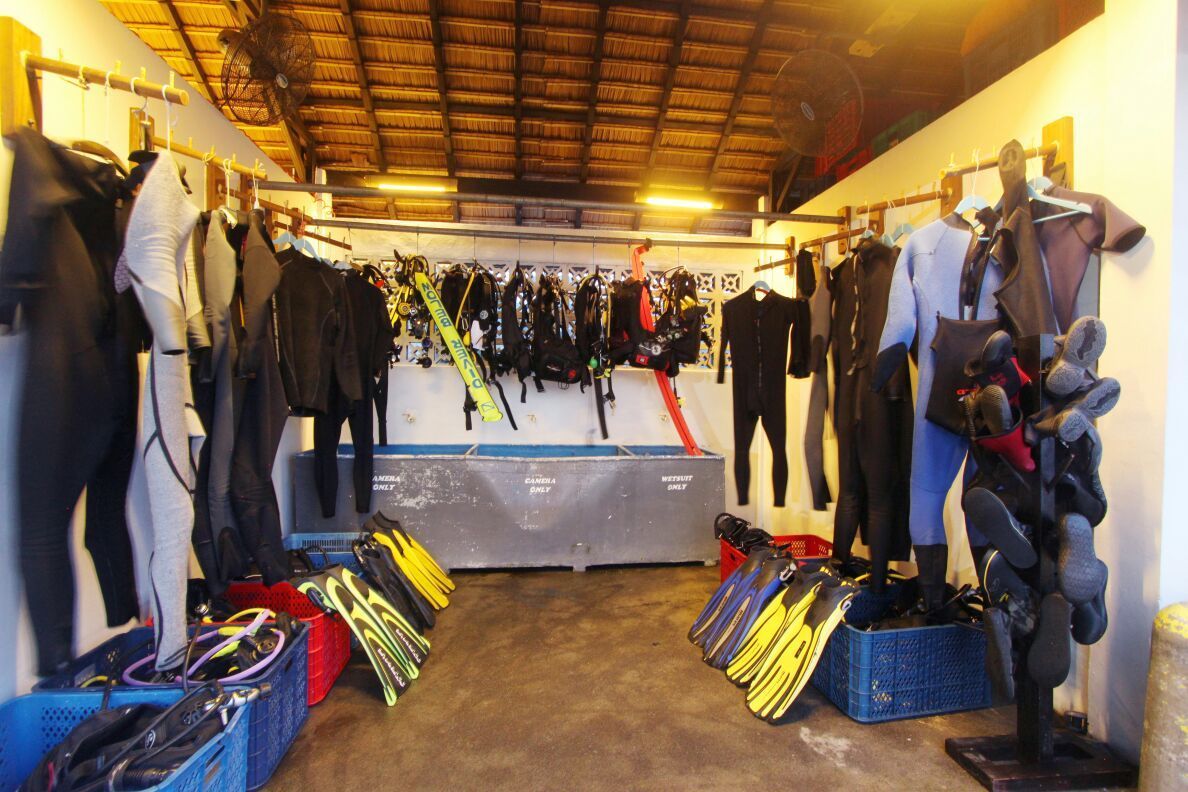 A room filled with scuba gear including wet suits and flippers