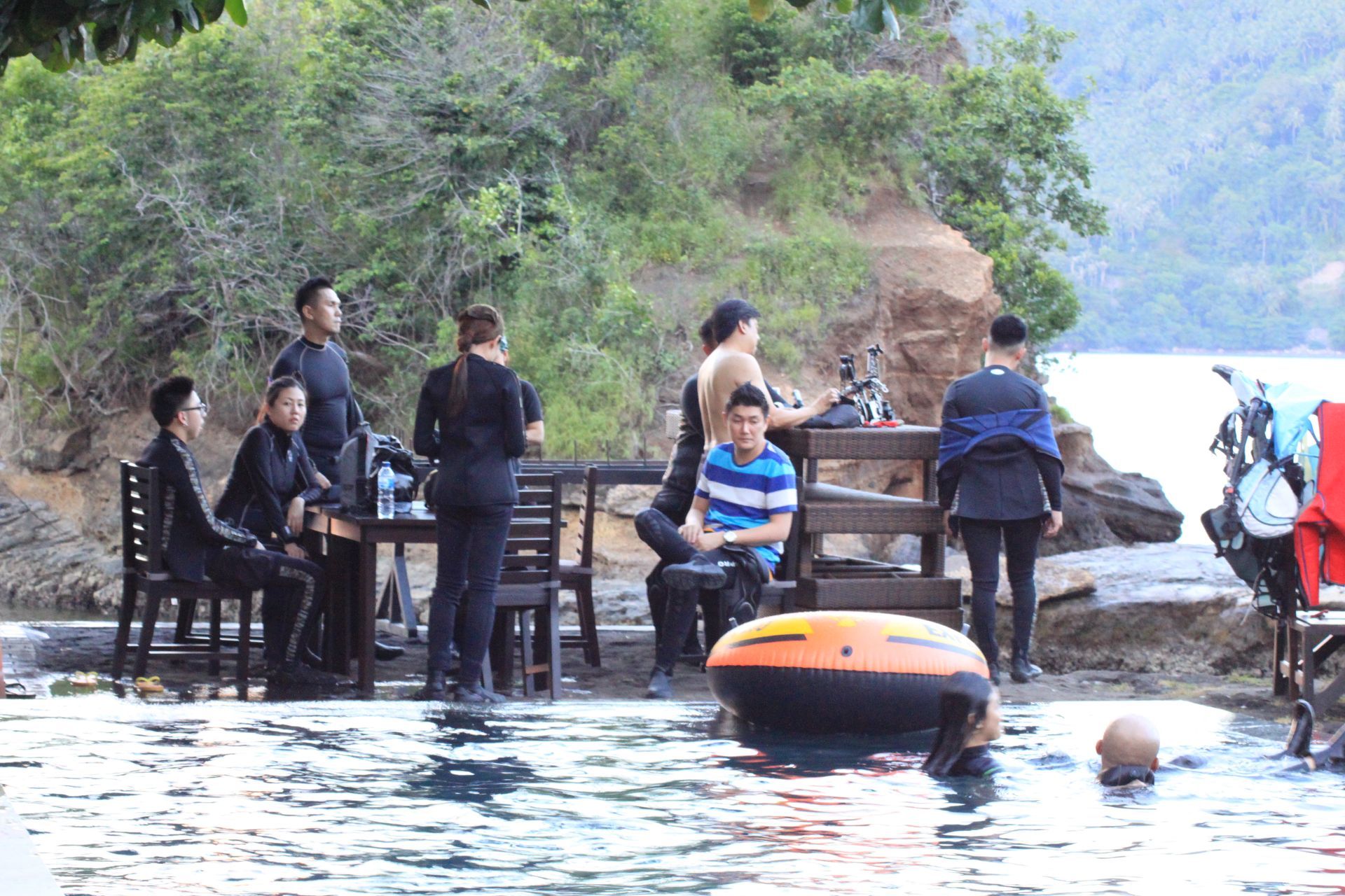 A group of people are sitting at a table in the water.